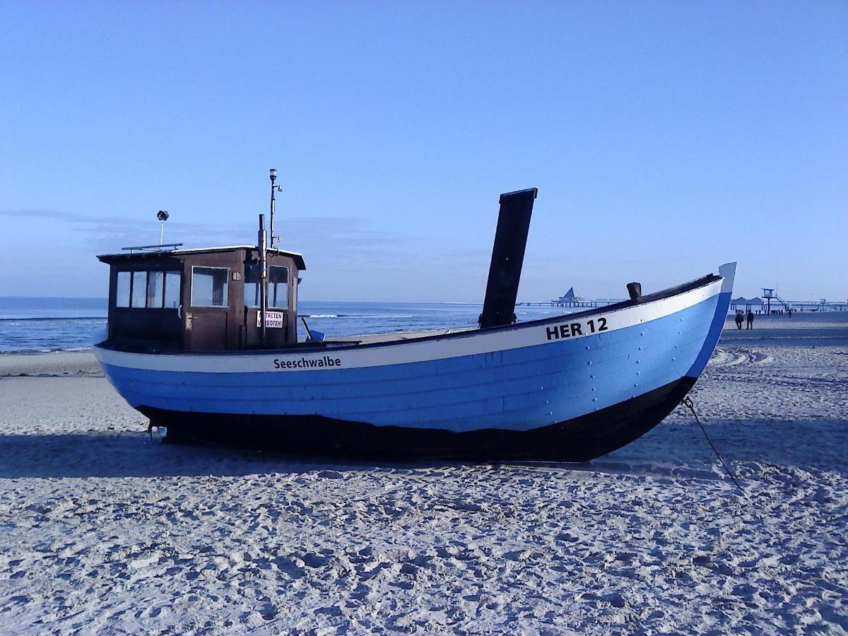 Blau-weißes Fischerboot Seeschwalbe am Strand von Heringsdorf